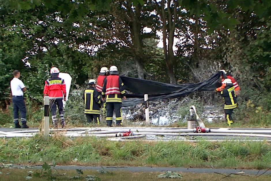 Feuerwehrleute an der Unfallstelle. Das Leichtflugzeug ging nach dem Absturz in Flammen auf.
