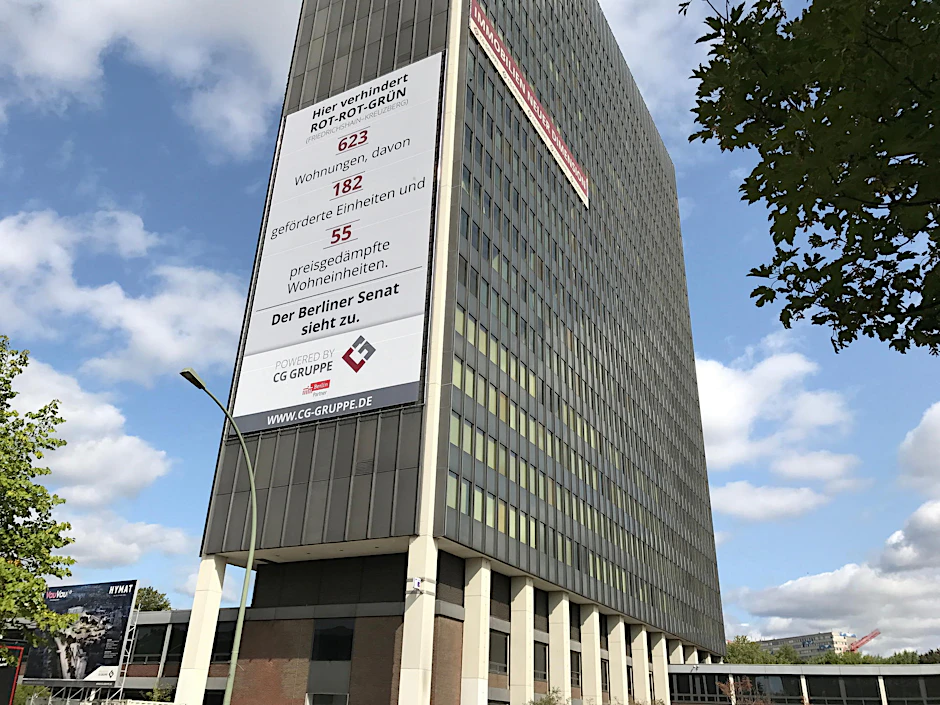 Riesen-Plakat wegen Riesen-Zoffs ums Postscheckamt: Bauherr wirft Stadtrat „Dilettantismus“ vor.
