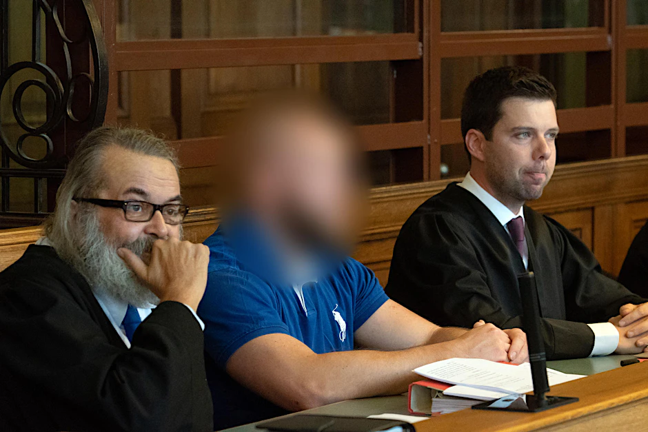 Einer der Angeklagten (Mitte) sitzt in einem Gerichtssaal. Dort muß er sich mit einem weiteren Angeklagten erneut wegen des illegalem Autorennens mit tödlichem Ausgang auf dem Kurfürstendamm verantworten. 