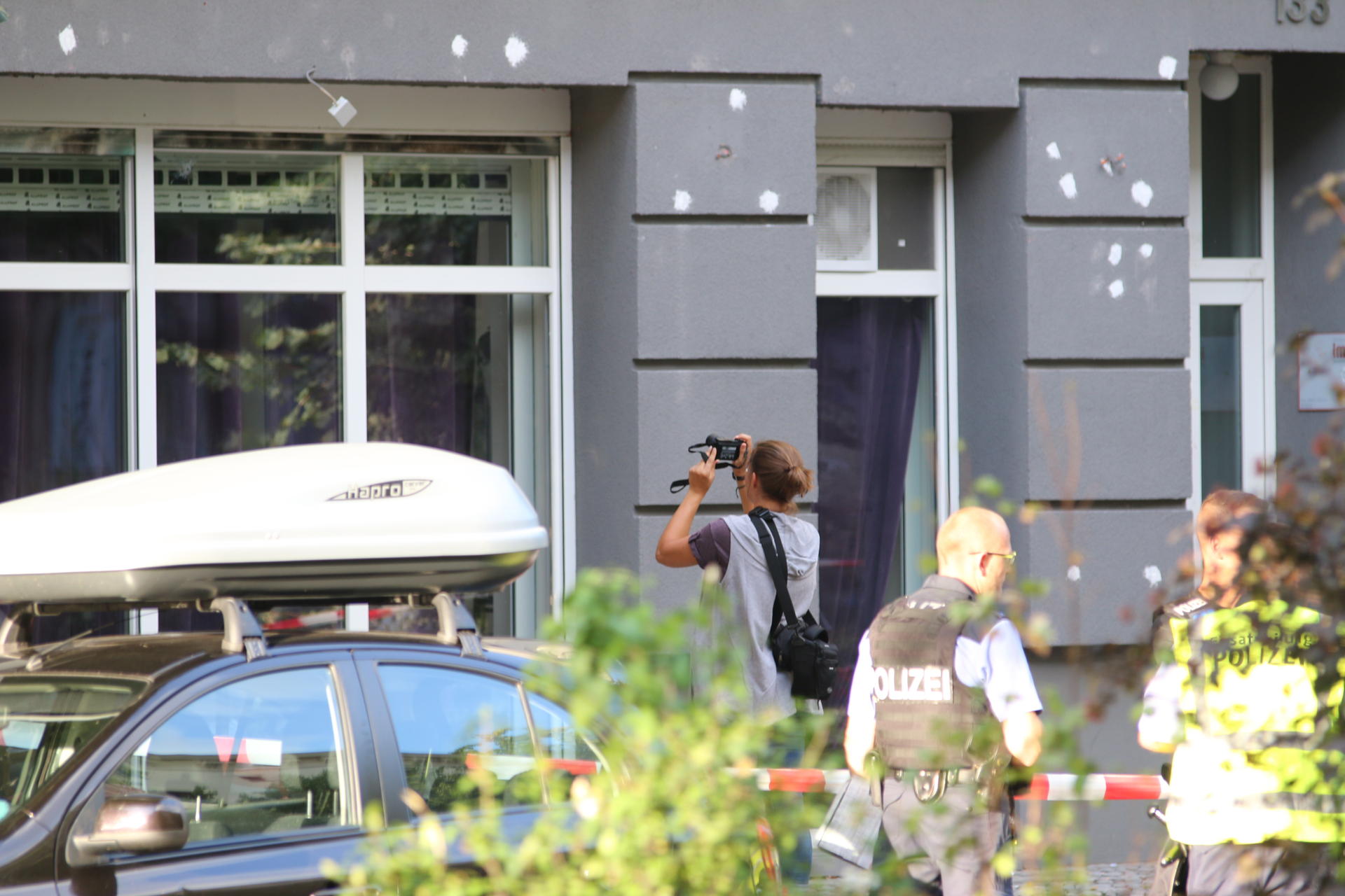 Ein Kriminaltechniker sucht nach Projektilen in einer Fassade an der Urbanstraße.