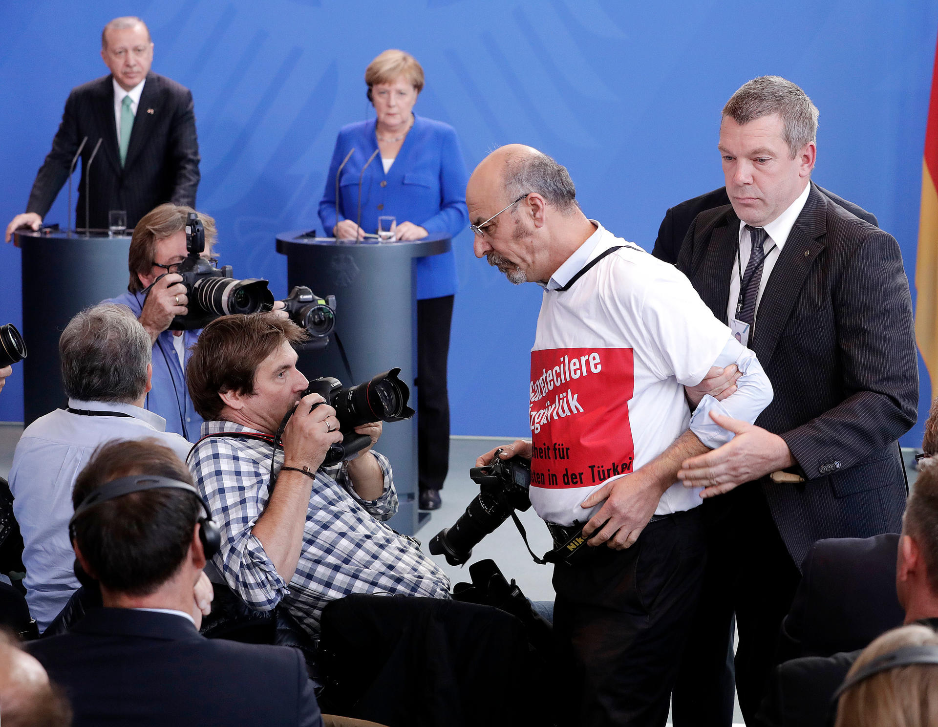 Ein Mann trägt bei der gemeinsamen Pressekonferenz von Bundeskanzlerin Merkel und Erdogan, Präsident der Türkei, im Bundeskanzleramt ein T-Shirt mit der Aufschrift "Pressefreiheit für Journalisten in der Türkei".