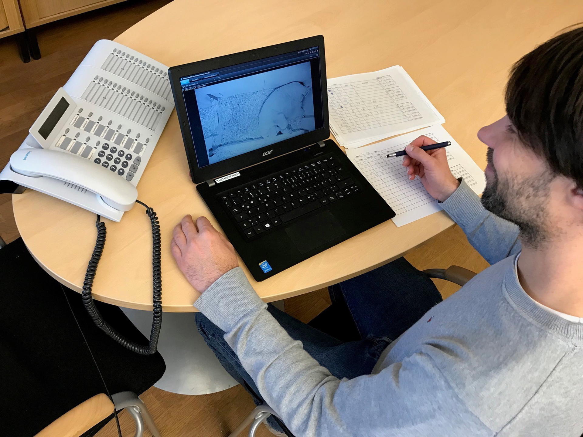 Kurator Florian Sicks sieht am Laptop, wie die Eisbärin ihr Junges versorgt.