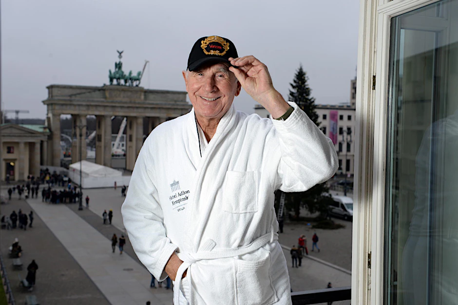 Frédéric Prinz von Anhalt steht im Bademantel am Adlon-Fenster und begrüßt Berlin.