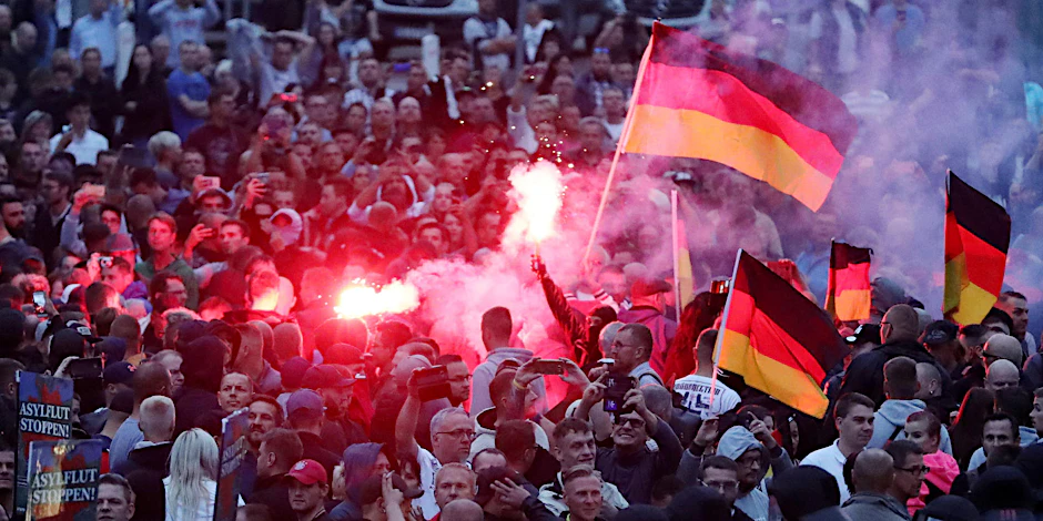 Demonstranten der rechten Szene zünden in Chemnitz Pyrotechnik und schwenken Deutschlandfahnen. 