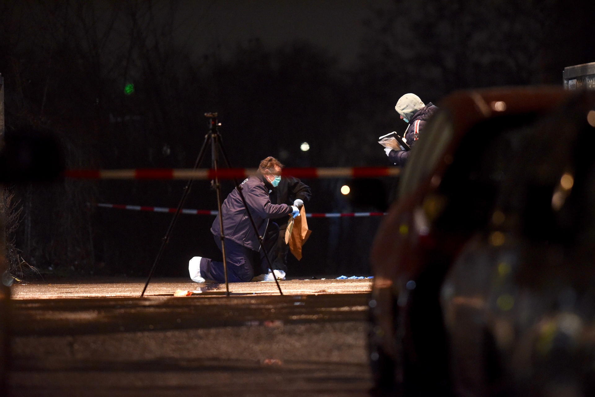 Polizisten mit Mundschutz sichern Spuren am Tatort. 