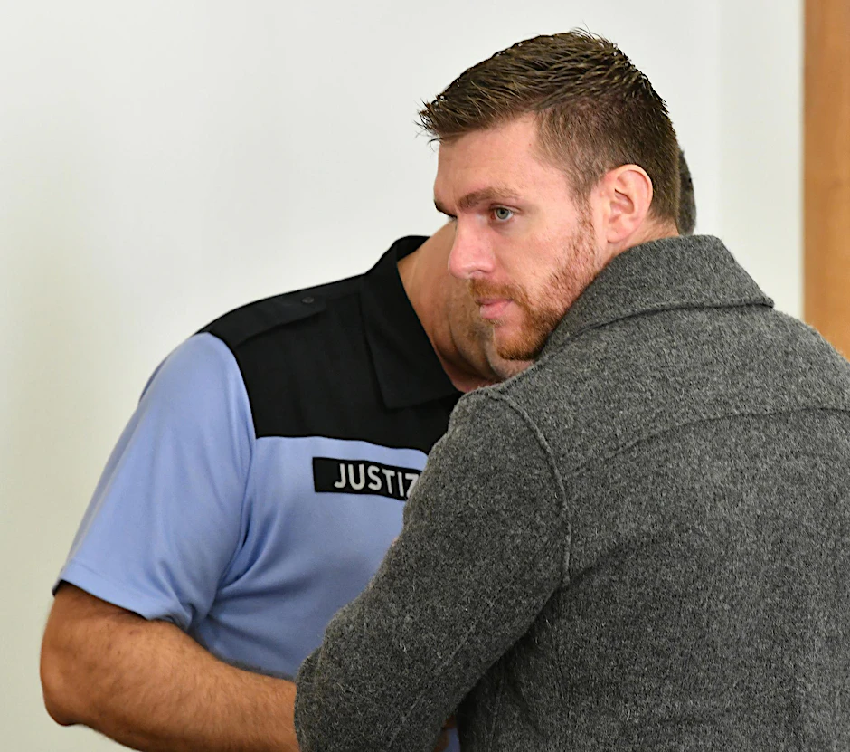 Ein Justizbeamter nimmt dem früheren NPD-Politiker Maik Schneider im Gerichtssaal die Handschellen ab. (Archivbild)