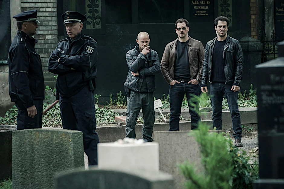 Antonio Wannek (3. v. l.) als Hans Kuscha, Felix Kramer (2. v. r.) als Ostberliner Polizist Kurt Grimmer und Fahri Yardim (r.) als deutsch-türkischer Polizist Erol Birkan in einer Filmszene aus "Dogs of Berlin".
