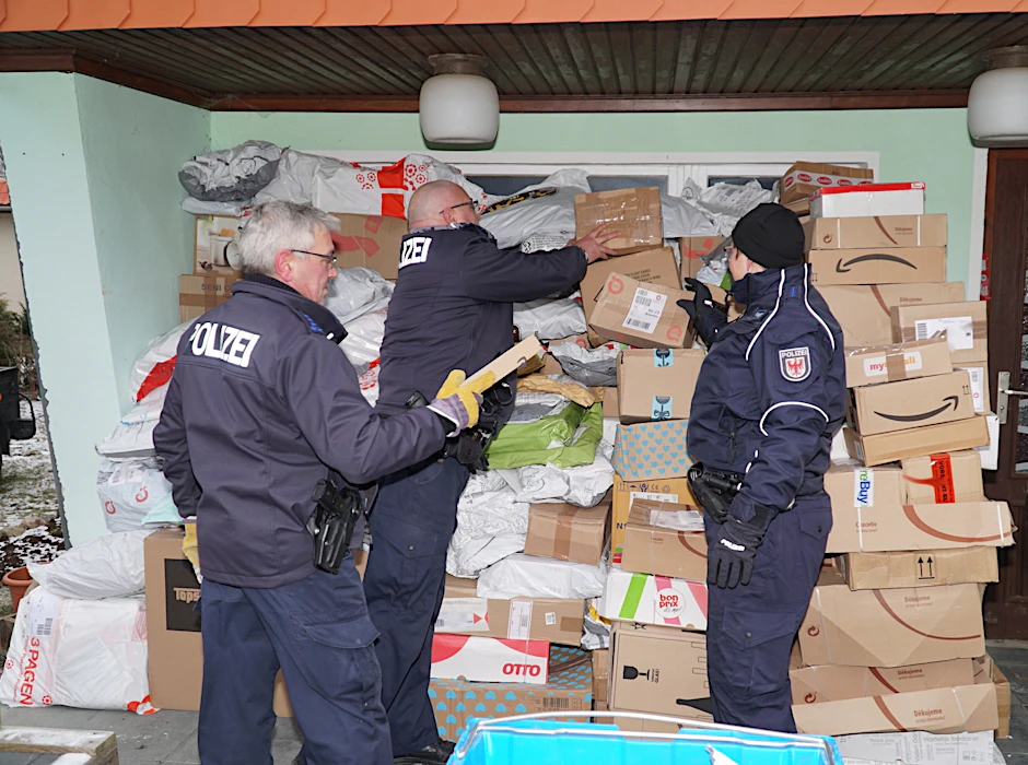 Polizisten beim Sichten der unterschlagenen Sendungen. Aus Platzmangel bunkerte der Mann  seine Beute sogar auf einer Terrasse. Die Polizei stellte sie sicher. 