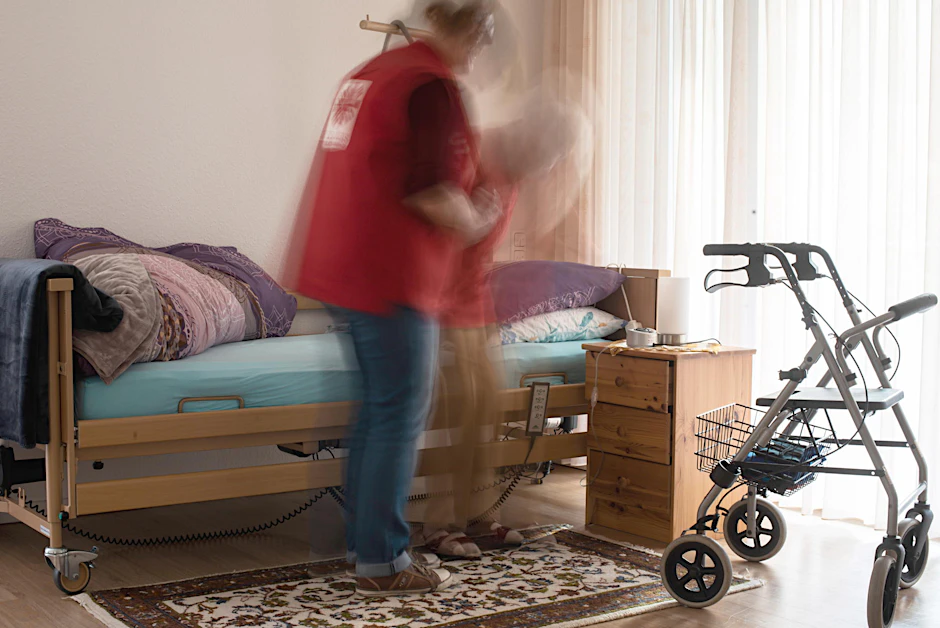 Schwere Arbeit, schlecht bezahlt: Eine Pflegedienst-Beschäftigte hilft einer hilfsbedürftigen Frau aus dem Bett.