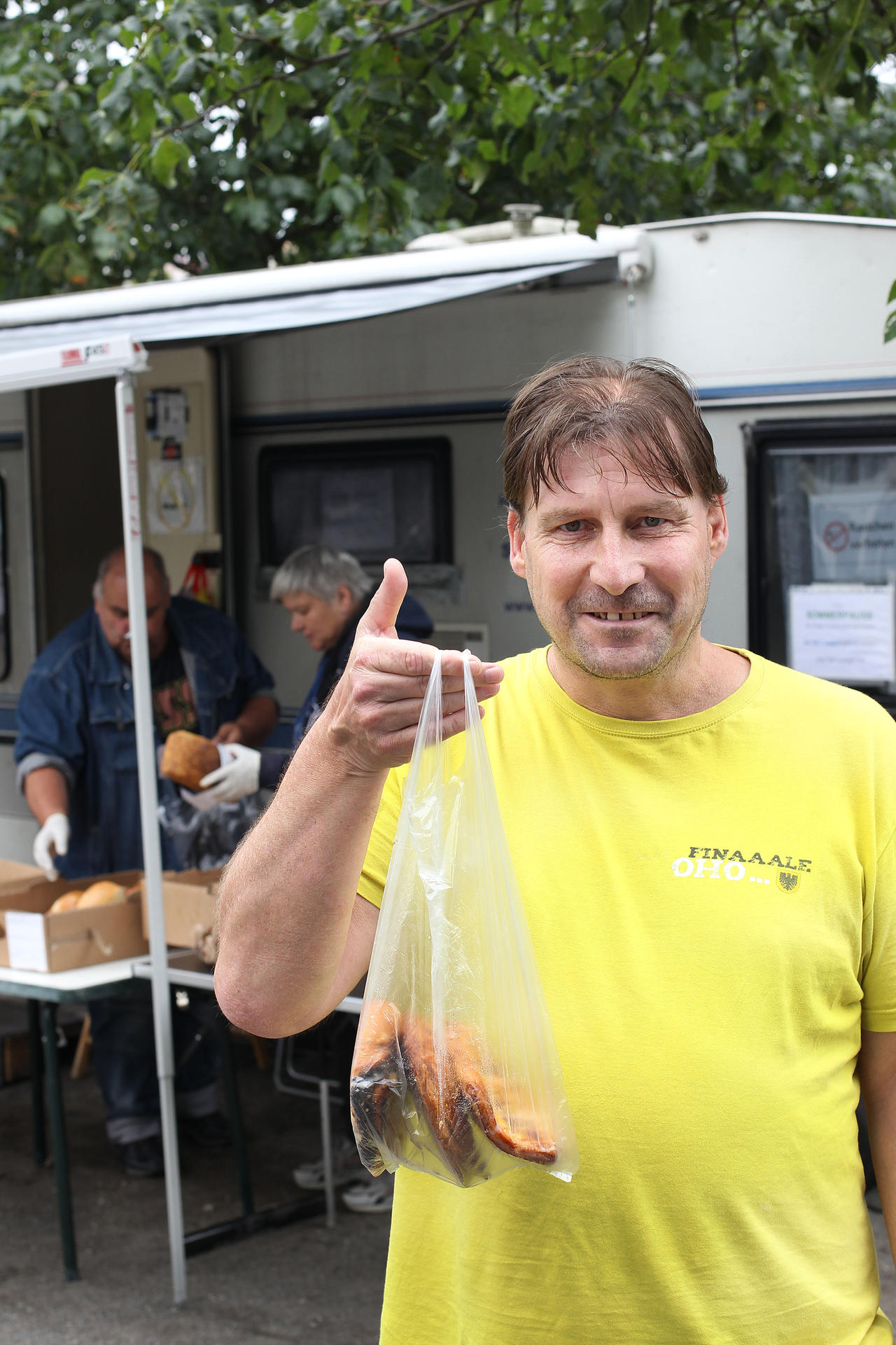 Rentner Thomas B. mit einer Tüte frischer Backwaren von Kamps, die seit kurzem nach Feierabend auf dem Franz-Neumann-Platz verteilt werden.  