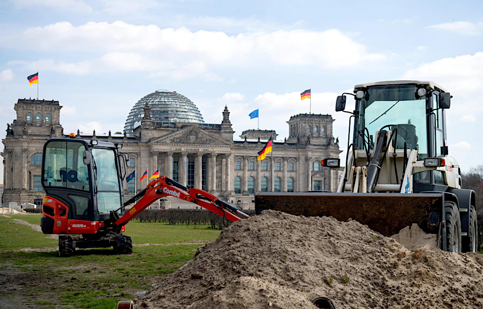 Zwei Bagger stehen auf dem Rasen vor dem Reichstagsgebäude.