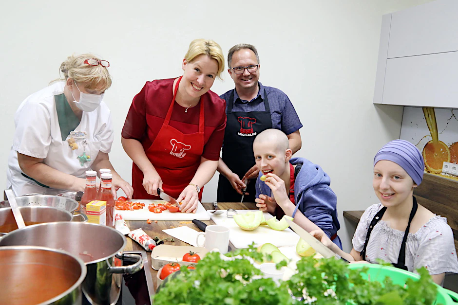 Die Ministerin schneidet Tomaten und spricht mit Lea und Carolina (re.) über die Chemo.