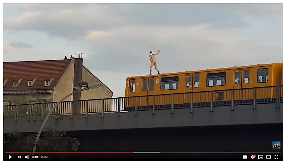 Ohne Kleidung steht dieser Mann nackt auf einem Zug und rast durch Berlin. 