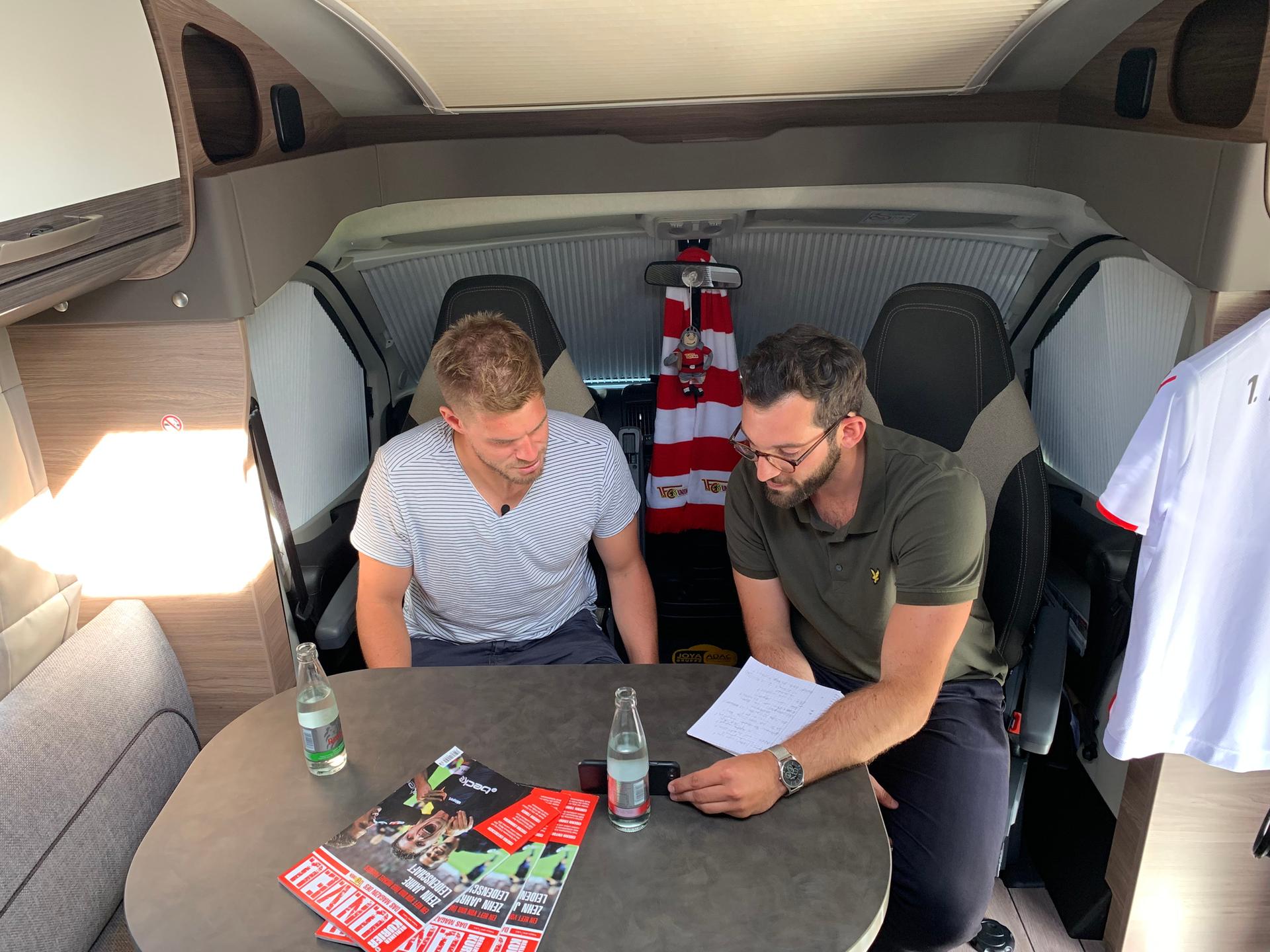 Reporter Patrick Berger zeigt Simon Terodde ein Video auf dem Handy.
