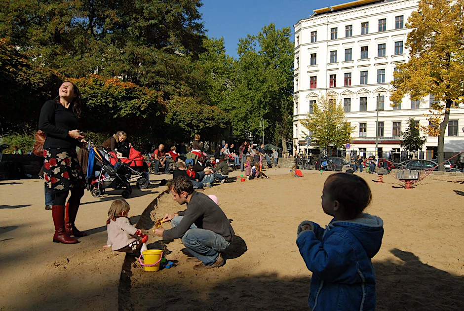 Eltern und Kinder auf dem Spielplatz am Kollwitzplatz in Prenzlauer Berg.
