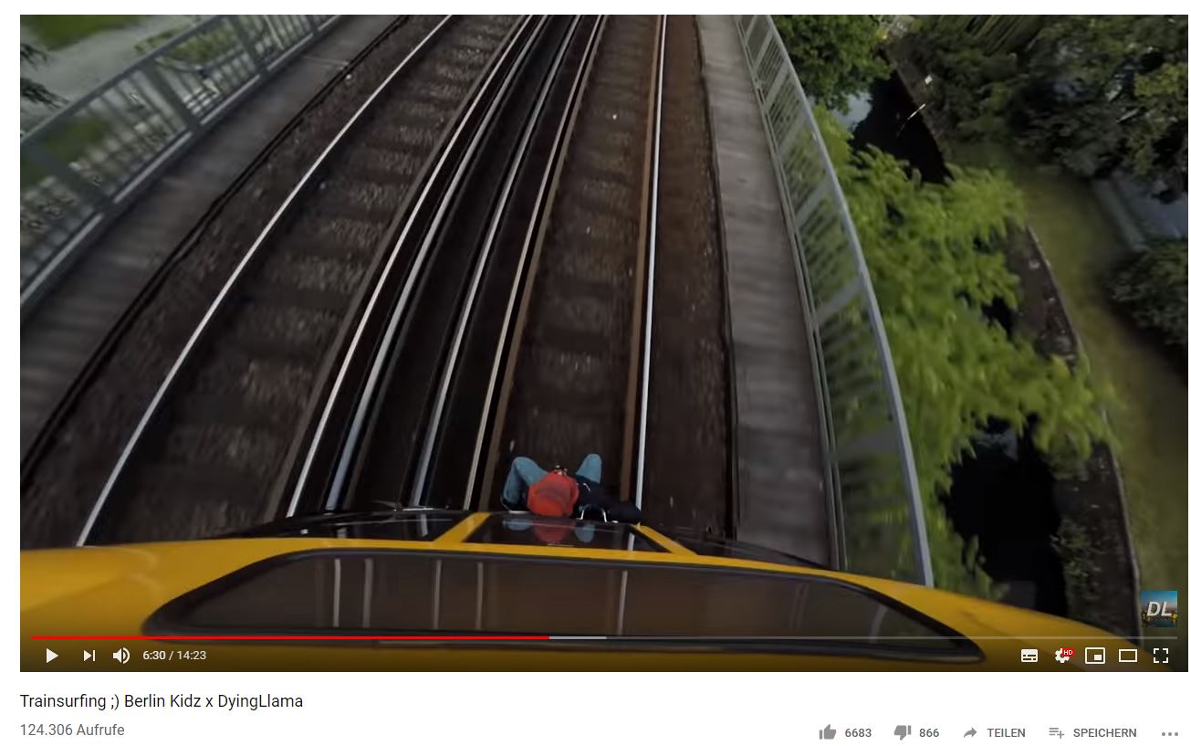 Einer der jungen Männer sitzt an der Spitze des fahrenden Zuges.