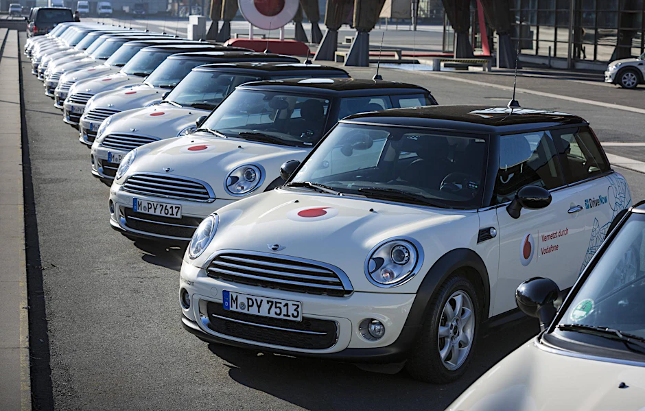 Mini Cooper Autos auf einer Reihe geparkt, vom Carsharing Unternehmen Drive Now (Symbolfoto)