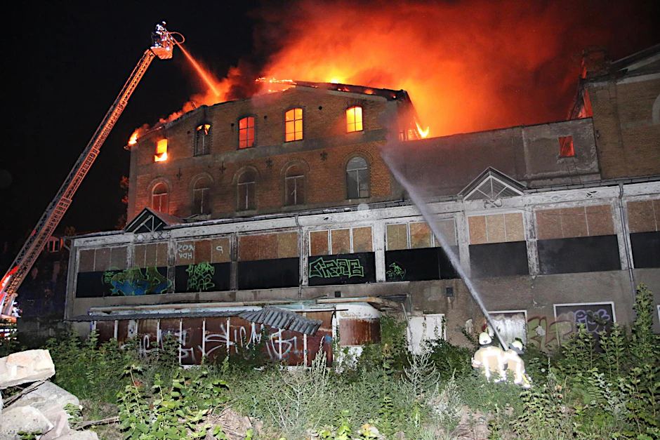 Feuerwehrkräfte bei den Löscharbeiten des denkmalgeschützten Gebäudeensembles in Grünau.