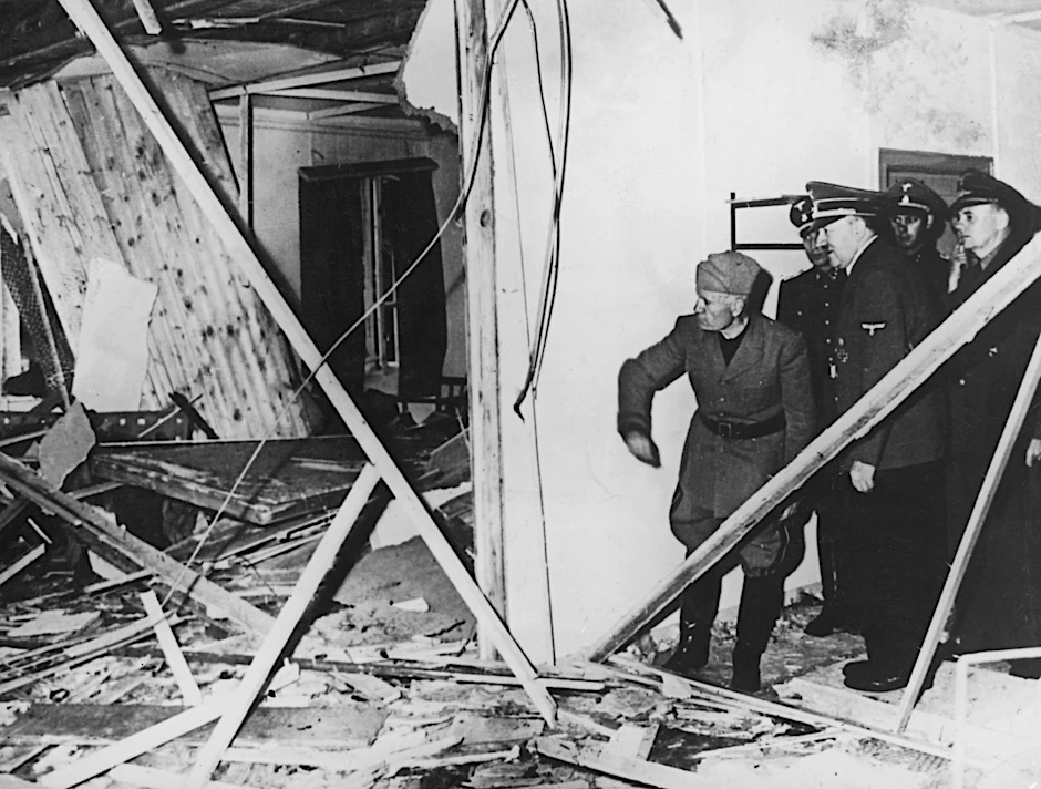 Als ein Zeichen der „Vorsehung“ betrachtete es Hitler, dass er das Attentat überlebt hatte – hier zeigt er Mussolini (ganz links) die zerstörte Baracke im „Führerhauptquartier Wolfsschanze“.  
