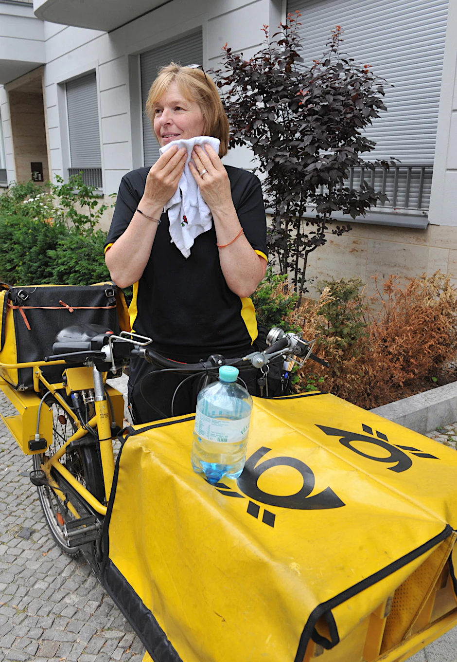 Bei der Gluthitze muss Manuela Kloß mehr Pausen machen. Mit einem Handtuch, das sie in einem Extra-Beutel mitnimmt, tropft sie sich den Schweiß vom Kinn.