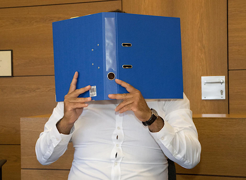 Im Gerichtssaal bedeckt der Zahnarzt sein Gesicht.