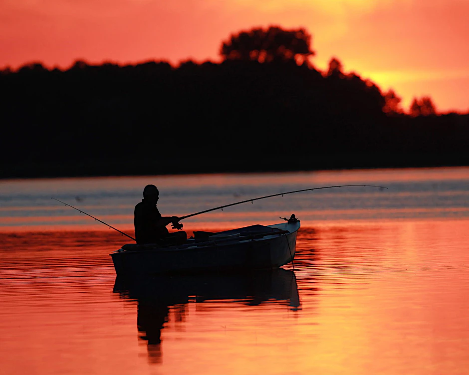 Ein Angler fischt während des Sonnenuntergangs im Arendsee (Archivbild).
