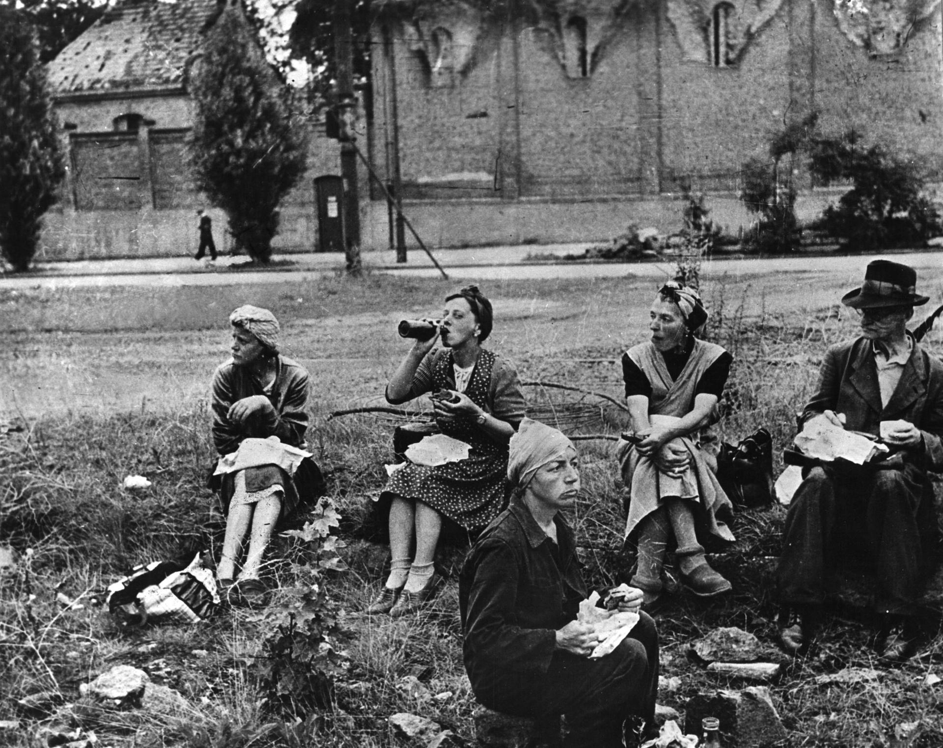 Ein karges Mahl unter freiem Himmel. Berliner Trümmerfrauen bei ihrer Mittagspause.  