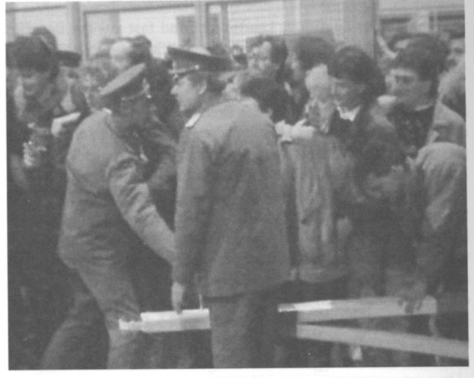 Harald Jäger (m.), befehlshabender Offizier am Grenzübergang Bornholmer Straße, lässt den Schlagbaum heben und die Kontrollen einstellen. 