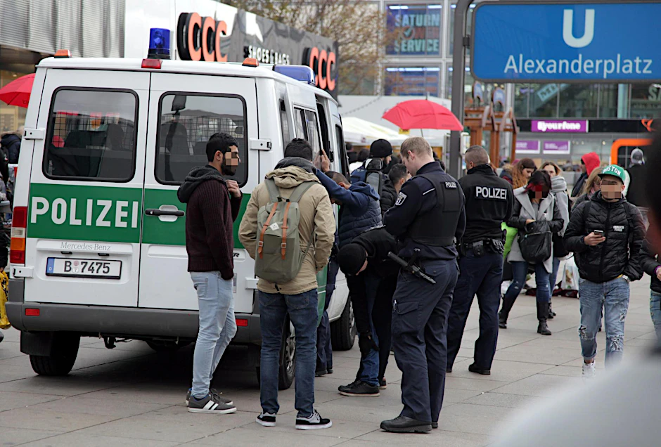Polizisten kontrollieren arabisch aussehende Männer nach einer Messerattacke am Alex. 