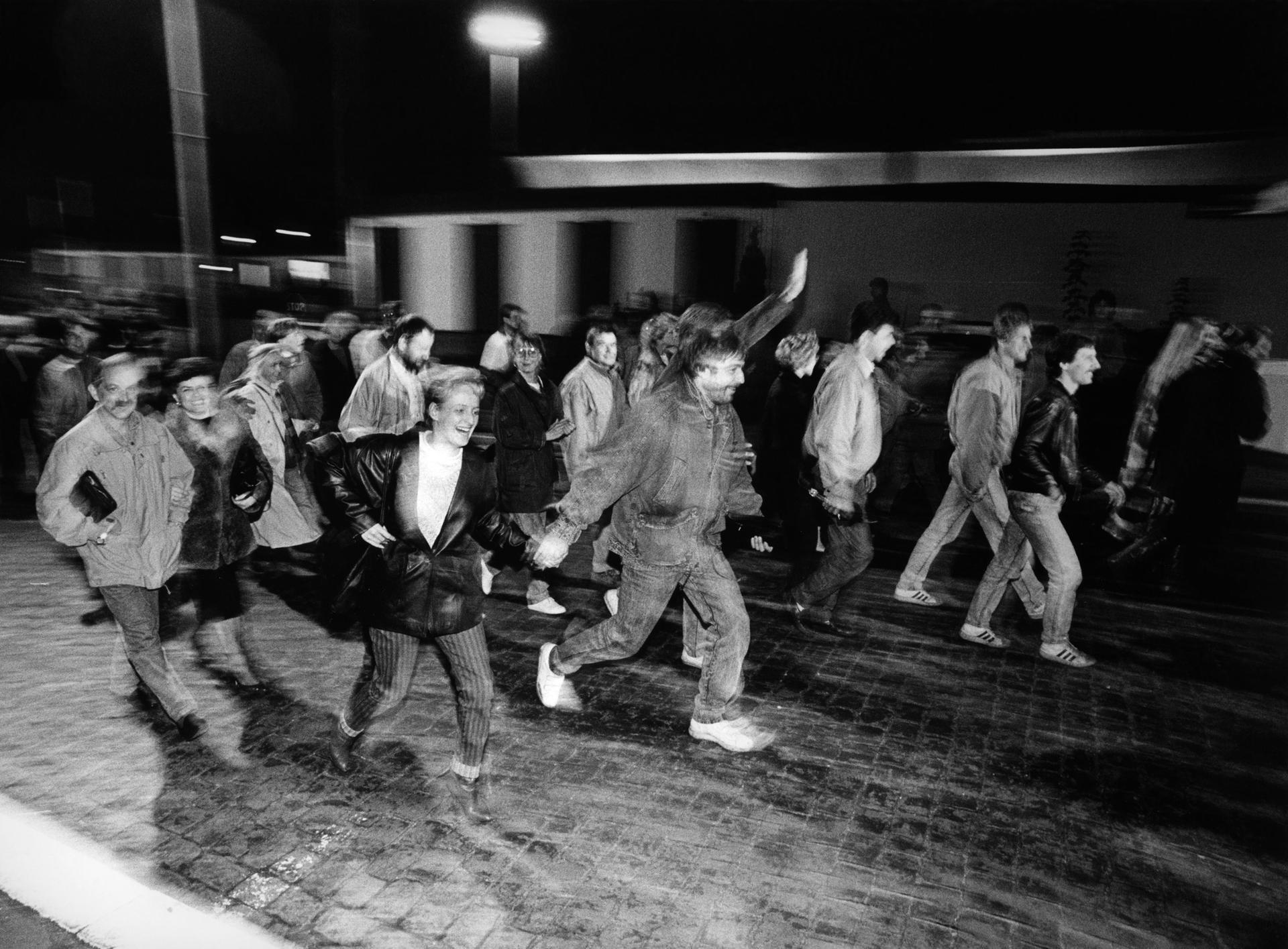 Mauerfall-Chronik: Hunderte DDR-Bürger laufen nach Öffnung des Grenzübergangs Bornholmer Straße Richtung West-Berlin. 