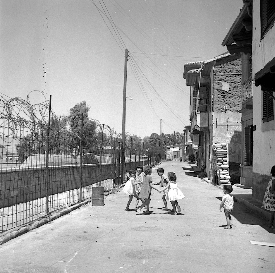1964: Kinder spielen an einem Zaun an der Berliner Mauer. 