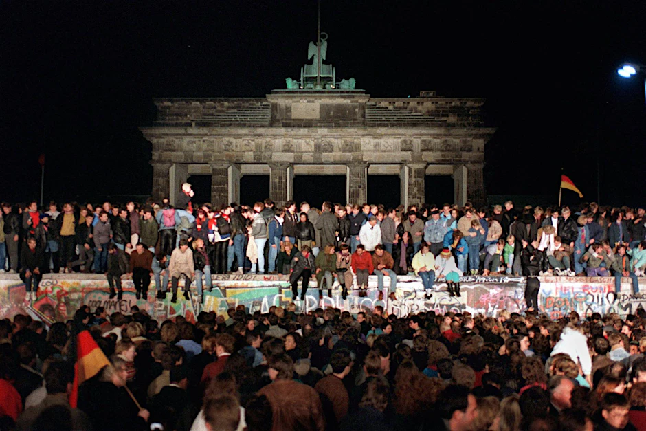 Mauerfall-Chronik: Jubelnde Menschen auf der Berliner Mauer am Brandenburger Tor am 10. November 1989. 
