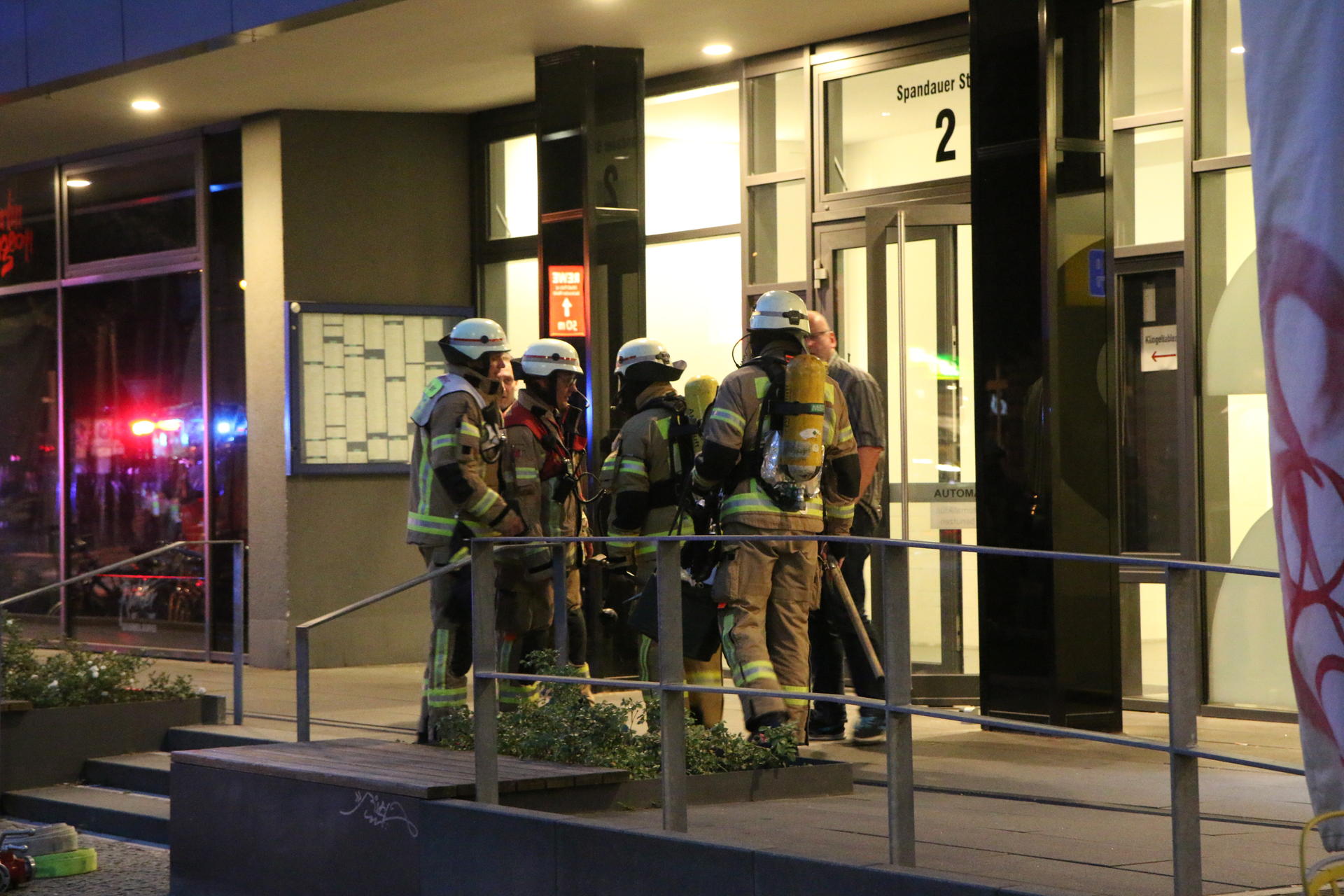 Einsatzkräfte der Feuerwehr vor dem Brandhaus in der Spandauer Straße in Mitte.