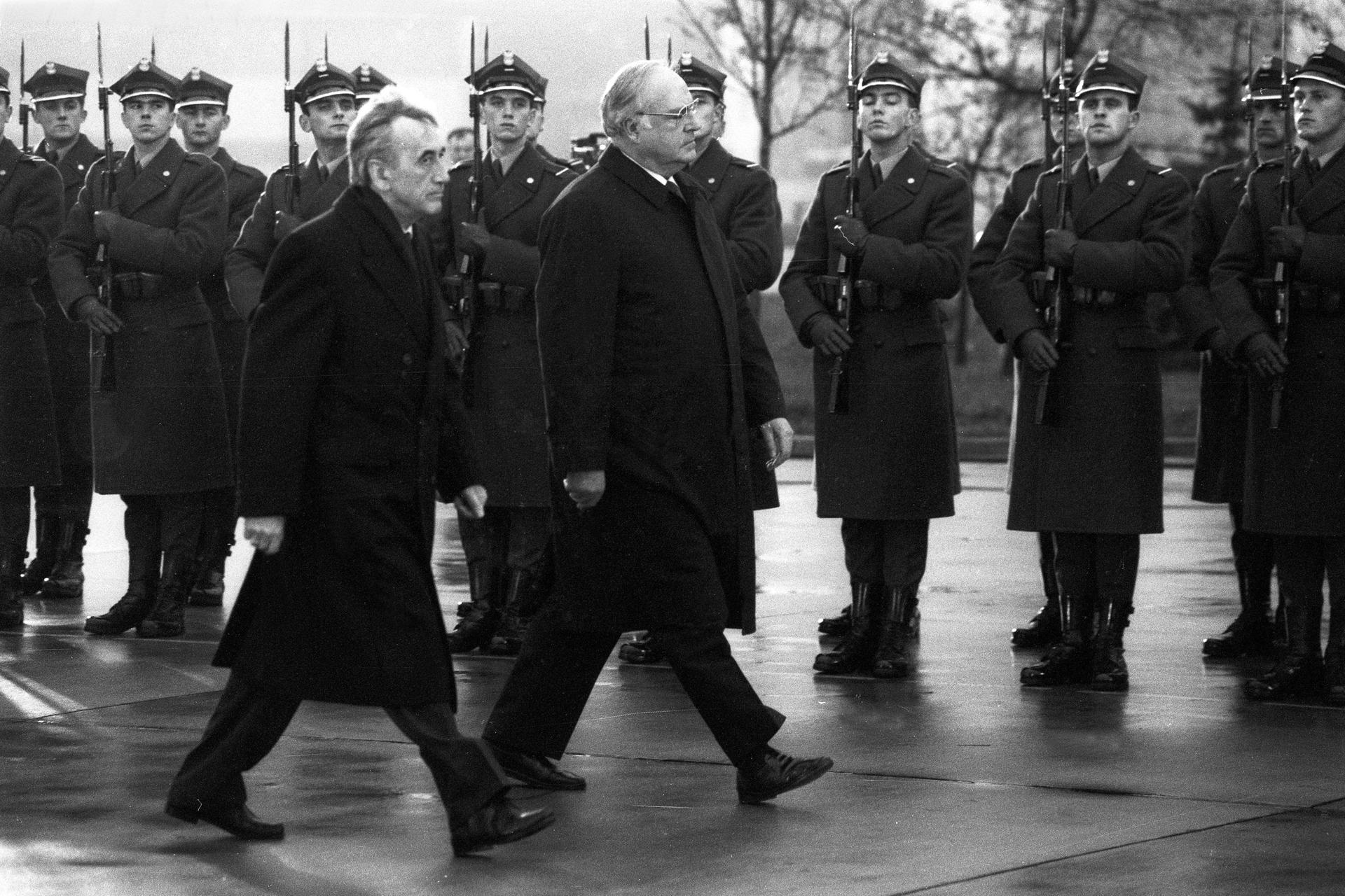 Mauerfall-Chronik: Auf Staatsbesuch in Warschau. Bundeskanzler Helmut Kohl und Polens Ministerpräsident Tadeusz Mazowiecki schreiten eine Ehrenkompanie ab.