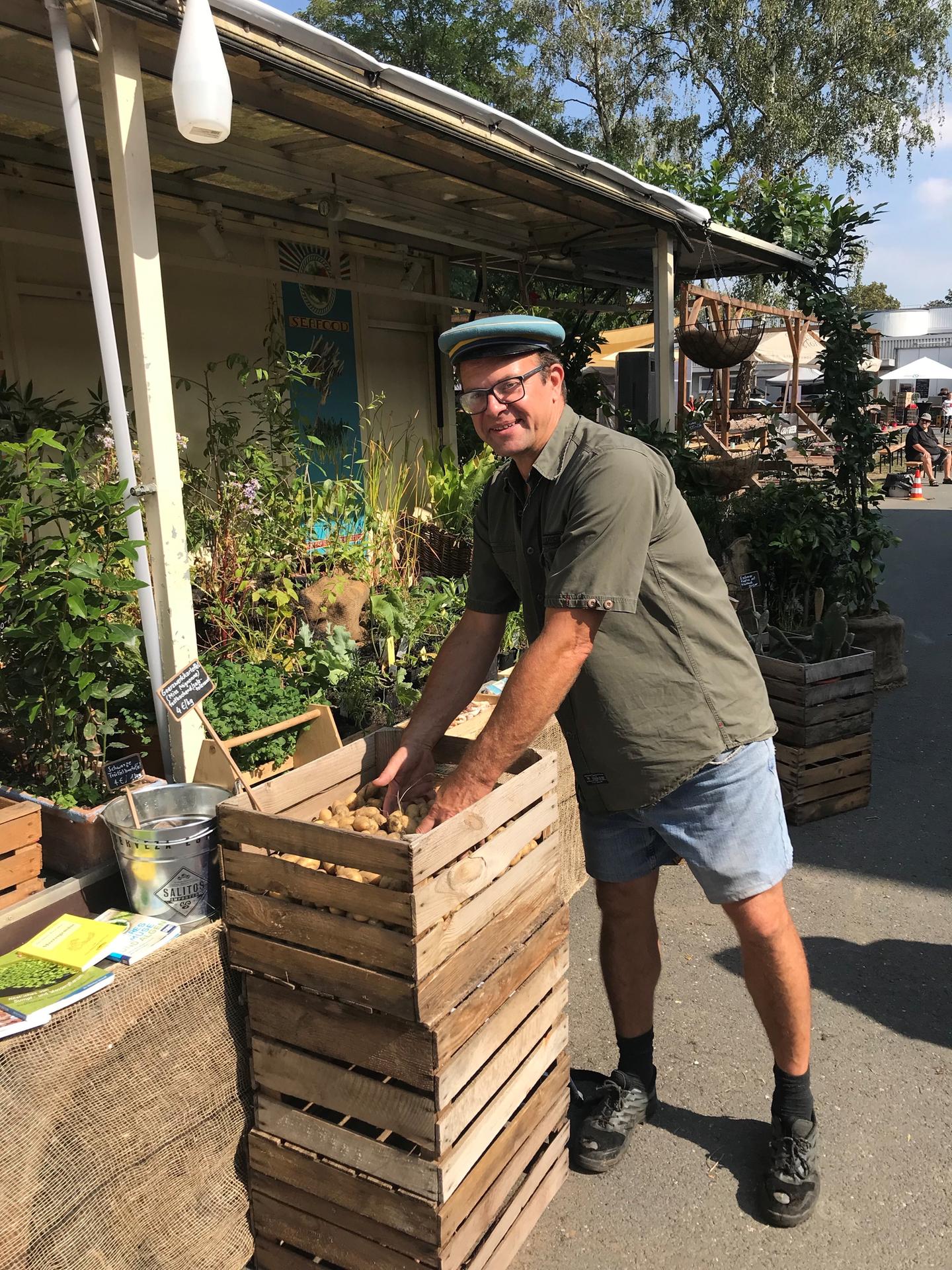 Gärtner-Stolz: Andreas Frädrich mit seinen Dach-Kartoffeln. Dahinter stehen diverse Pflanzen, die er zieht, und für deren Zubereitung er Kochbücher anbietet.