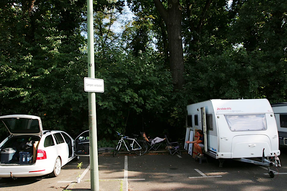 Die Verbotsschilder „Campen verboten!“ hängen überall in der Straße.