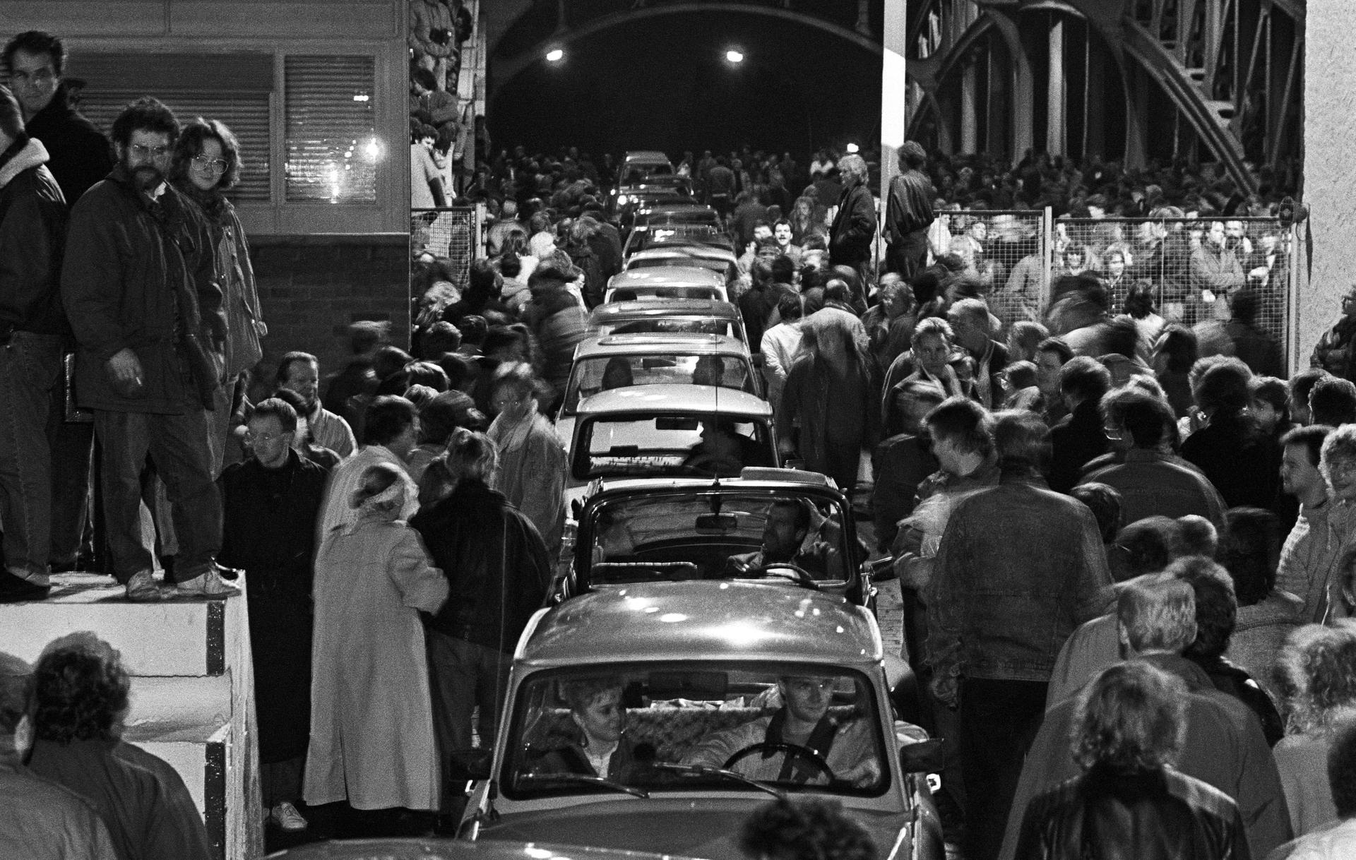 Mauerfall-Chronik: Fußgänger und Autos drängen sich im Laufe der Nacht auf der Bornholmer Brücke Richtung West-Berlin. 