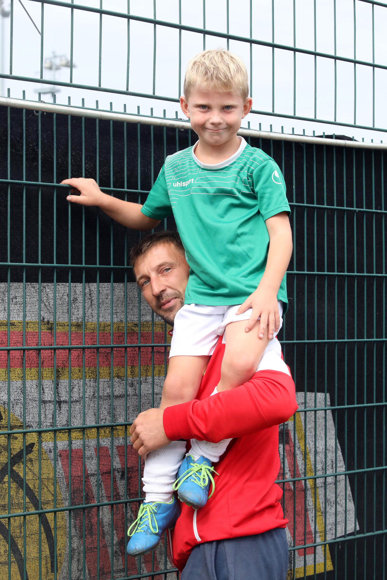 Benno (6) sitzt auf den Schultern von Papa Thomas. Er will sehen, ob Unioner hinter dem Zaun kicken.