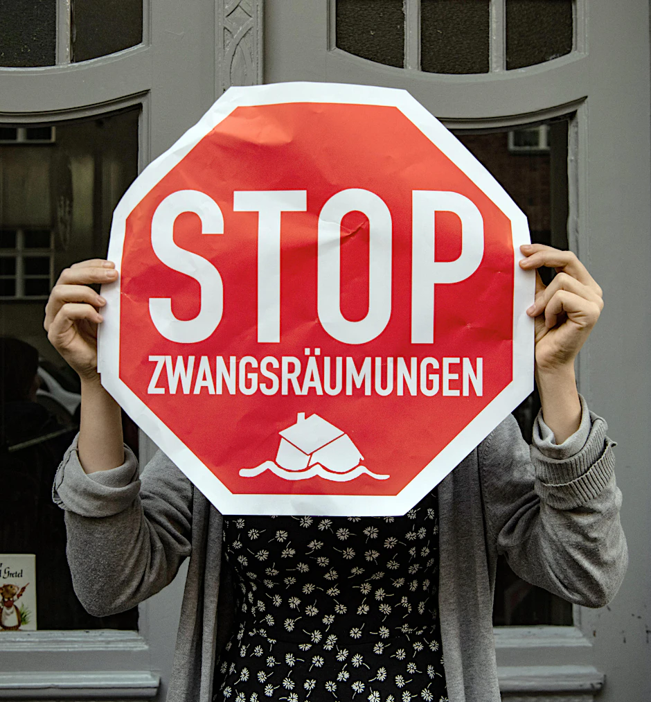 Eine Teilnehmerin an einem Protest gegen die Zwangsräumung einer Wohnung an der Dubliner Straße 18 in Wedding hält ein Plakat. 