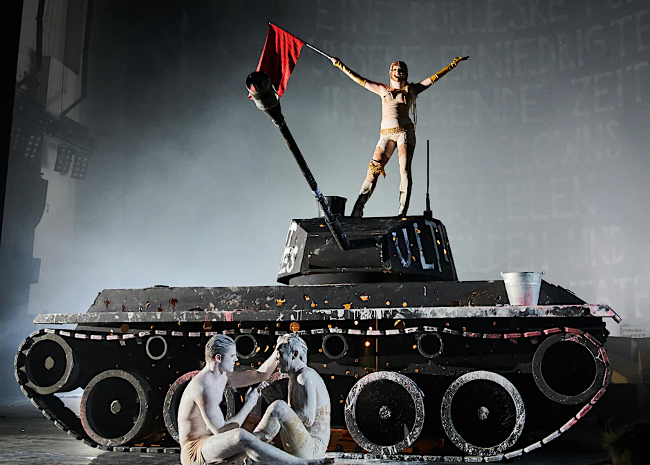 Jella Haase Fahne schwenkend auf einem Panzer. Sie ist kaum wiederzuerkennen.