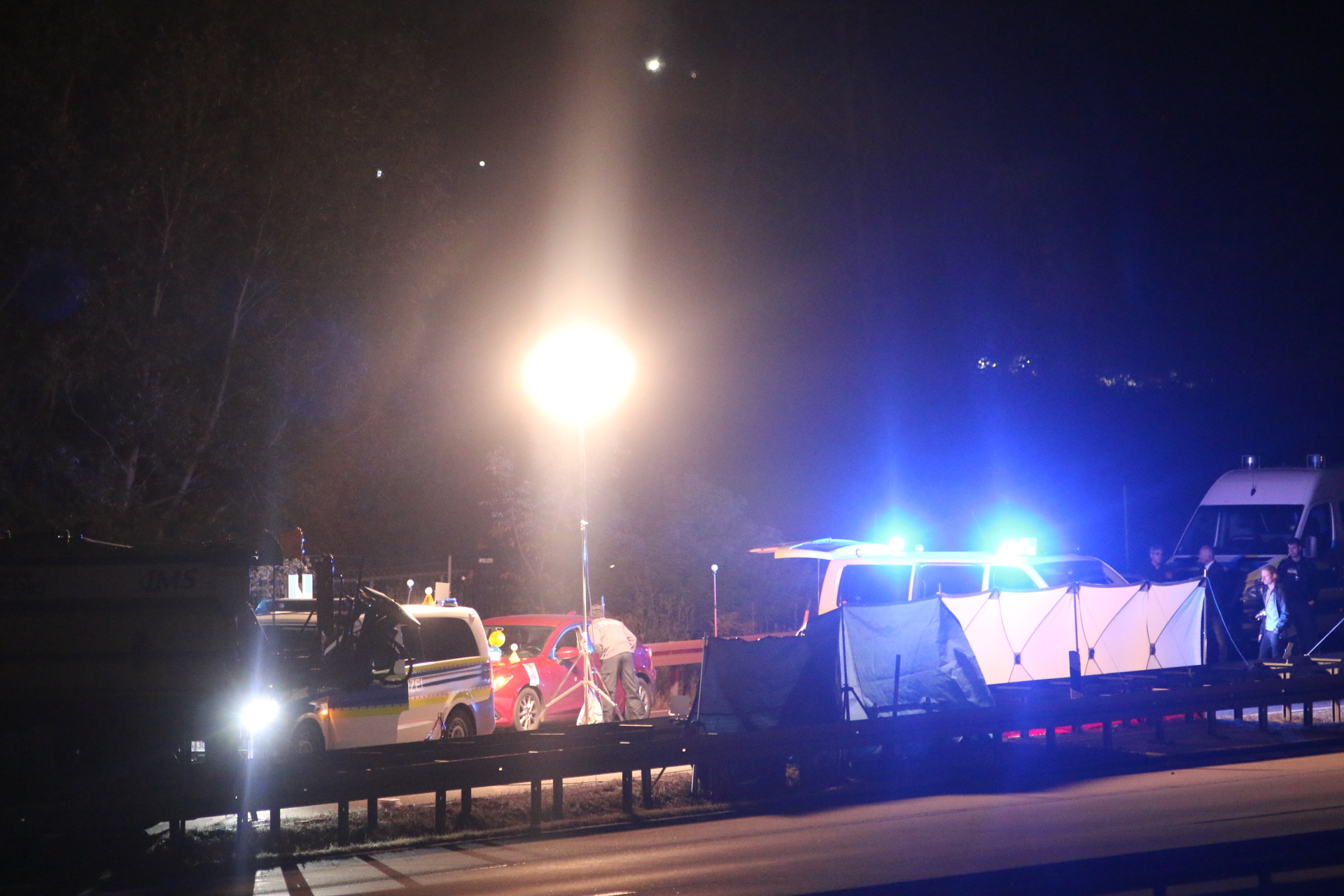Der Einsatzort ist weiträumig abgesperrt. Zu erkennen ist das rote Auto, in dem der mutmaßliche Straftäter saß.