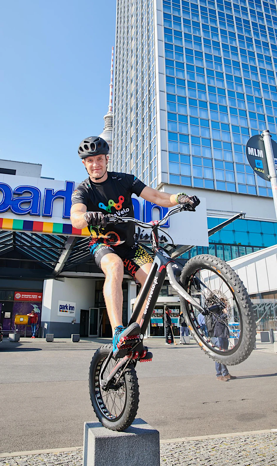 Der polnische Trial Biker Krystian Herba macht sich mit seinem Rad vor dem Park Inn Hotel warm. 