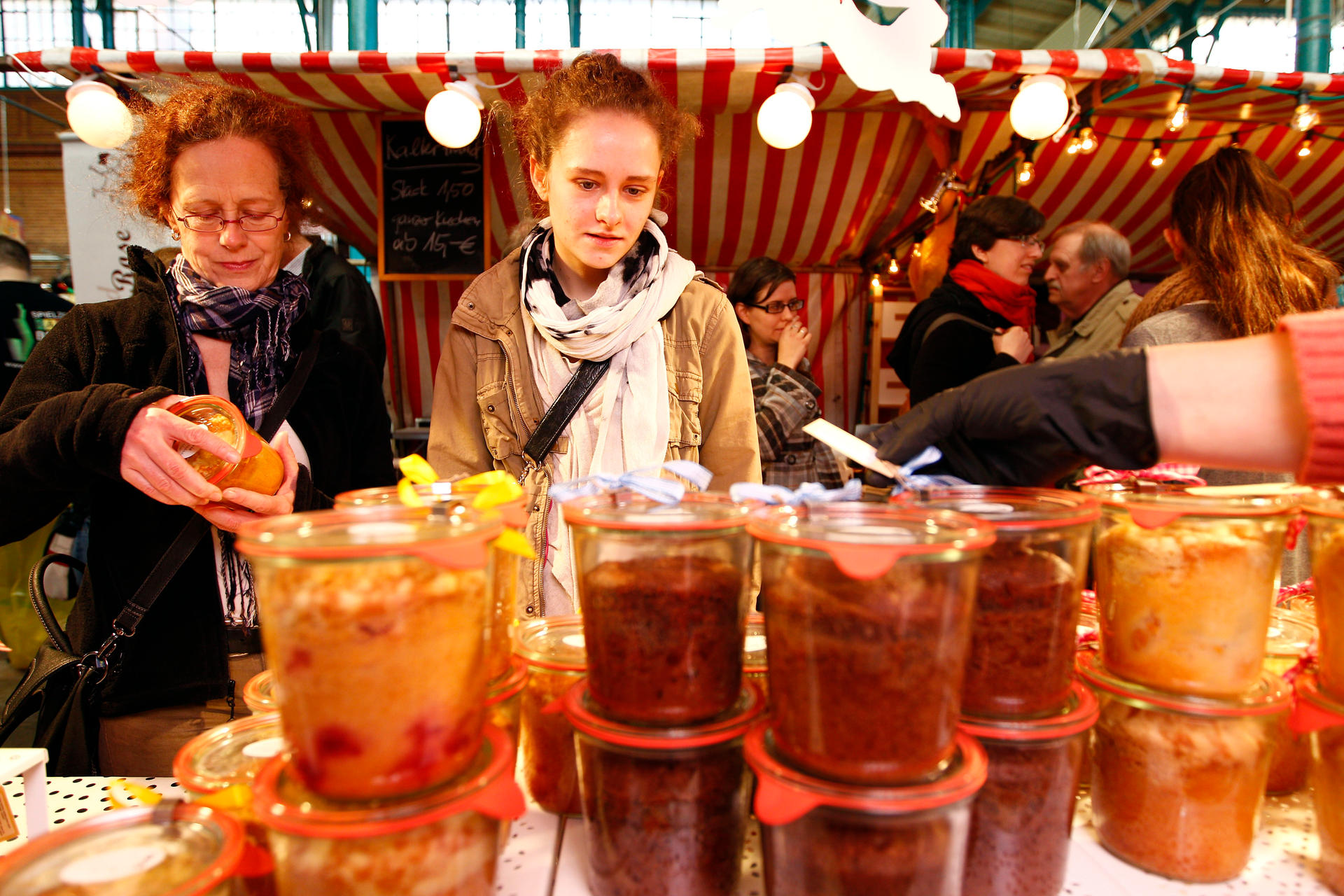 Besucher testen Leckereien auf dem Naschmarkt in der Markthalle Neun. 