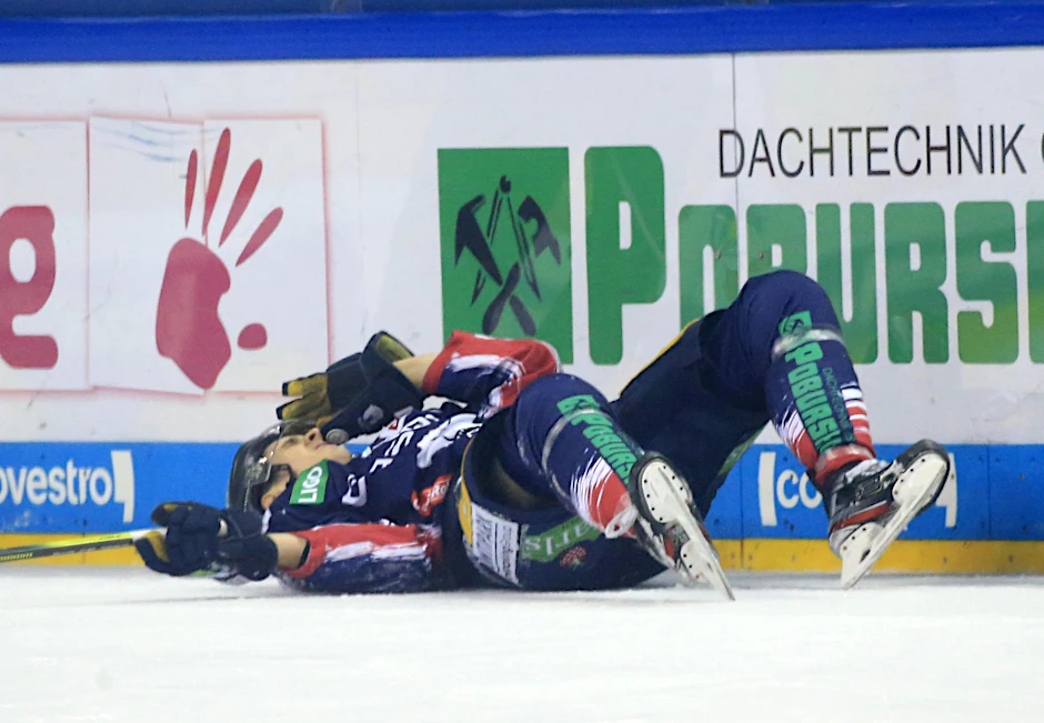 Eisbären-Stürmer Louis-Marc Aubry krümmt sich mit Schmerzen auf dem Eis.