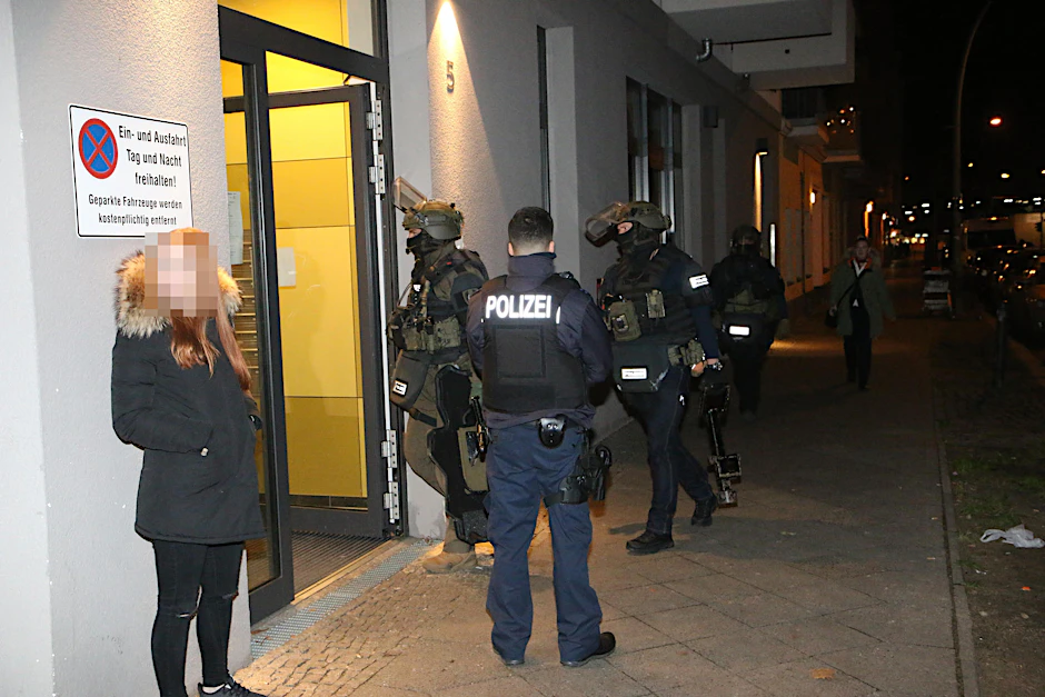 Alle Mann rein da: Die Elitepolizisten auf dem Weg ins Haus, die bedrohte Frau steht daneben.