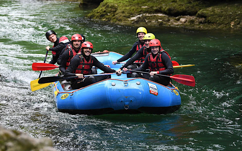 Die Unioner paddeln im blauen Boot über den Fluss.