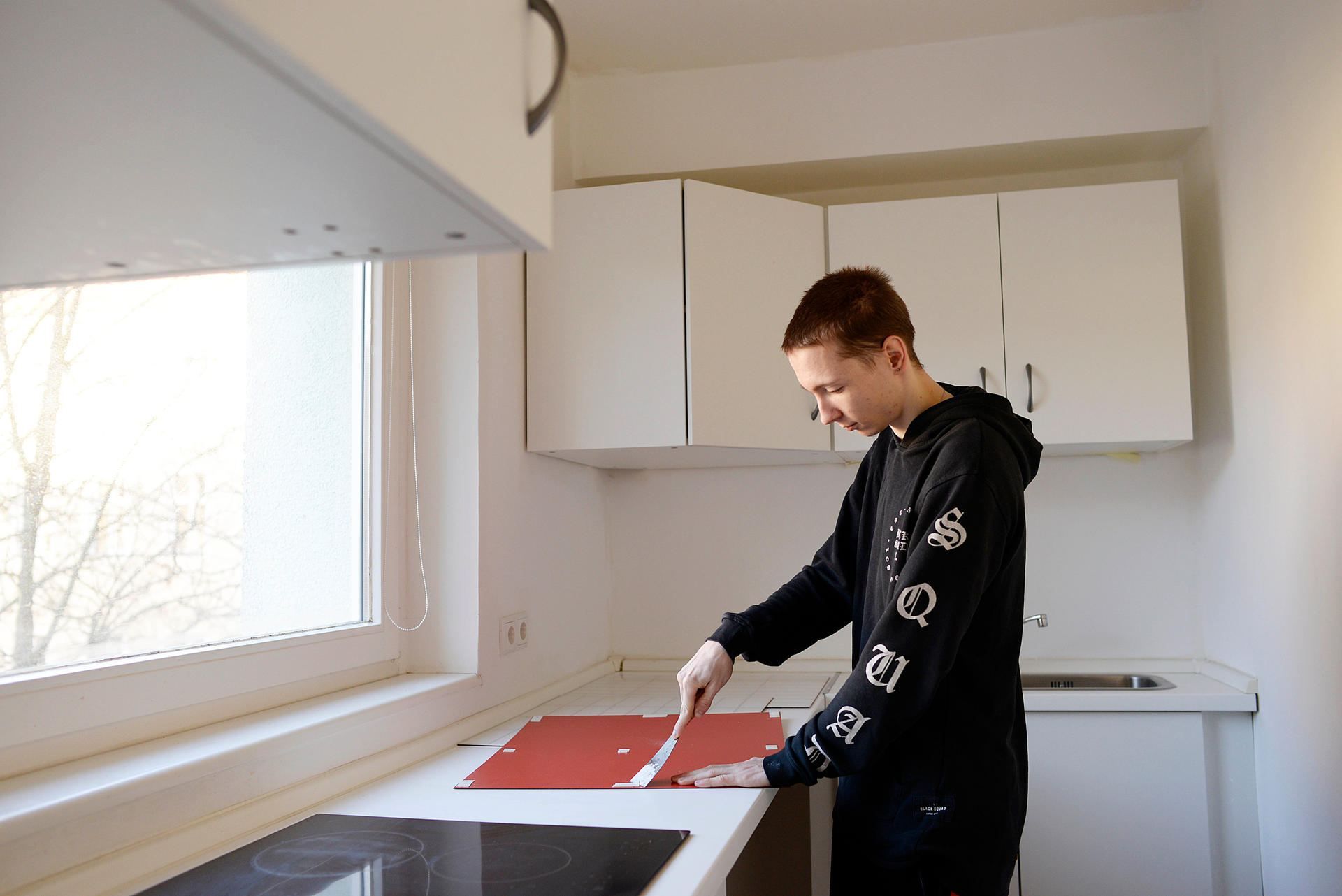 Jetzt steht Max in der Küche seiner neuen Wohnung und renoviert.