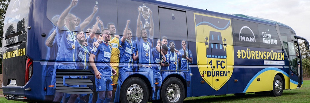 Auf dem vom Bayern-Sponsor für den 1. FC Düren zur Verfügung gestellten Bus für die Fahrt nach München und zurück prangt das Foto der Pokalübergabe nach dem Sieg des Fünftligisten im Landespokal-Finale über Alemannia Aachen (1:0).