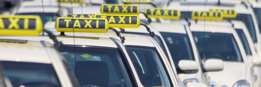 Mehrere Berliner Taxis stehen am Rande einer Demonstration. <br>