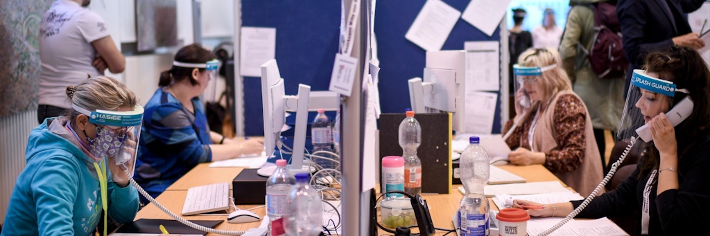 Mitarbeiter des Gesundheitsamtes Mitte mit Gesichtsschutzschirm telefonieren im Lagezentrum des Gesundheitsamt Mitte. Berlins Gesundheitsämter sind mitten in der Corona-Pandemie häufig unterbesetzt.